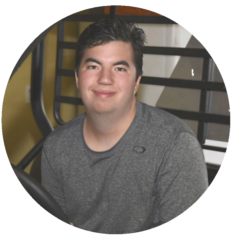 Image: Circular croppped photo of a young man with dark brown hairsitting down wearing a gray T-shirt and smiling.