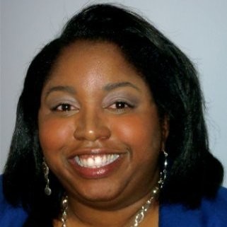 Image: Headshot of Cheryl Mitchell, a black woman with a blue blazer and long golden earings.