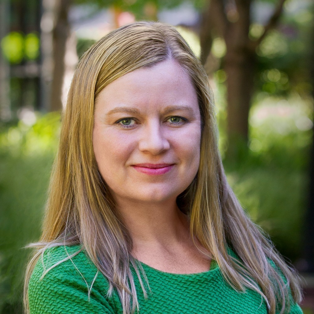 Image: Jaime Laitinen, a white woman with long blonder hair, wearing a green shirt and smiling.