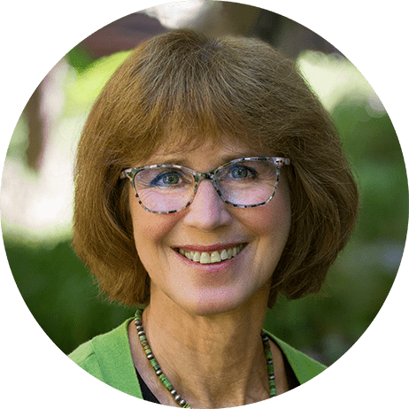 Photograph: Headshot of Debbie Moore, a white woman with short brown hair and glasses.